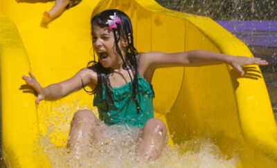 Children splashing down the yellow slide at Dippy’s Splash Zone